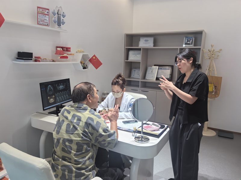 手语姐姐译员在门诊陪同听障老人就医，现场手语翻译